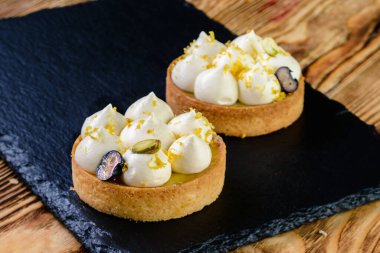 Lezzetli Mini tatlı tart tatlı pastalar, sade ahşap masa üzerinde pastalar.