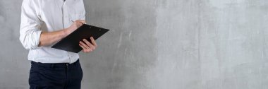 Beyaz gömlekli bir mühendis, dijital tablet üzerine yazı yazan bir mühendis beton duvara kopya spaz