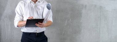 Beyaz gömlekli bir mühendis, beton duvar fotokopi alanının arka planında gülümseyen mühendis.