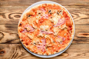 Tahta masa üstünde servis edilen leziz İtalyan pizzası.