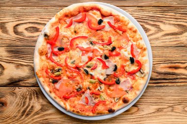 Tahta masa üstünde servis edilen leziz İtalyan pizzası.