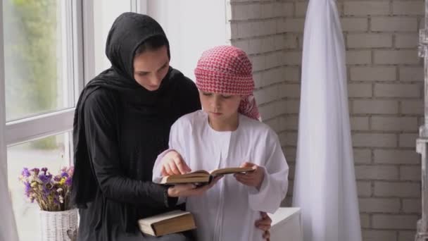 Árabe madre e hijo posando en interiores con libro — Vídeo de stock