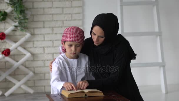 Arabe mère et fils posant intérieur et livre de lecture — Video