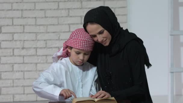 阿拉伯语的母亲和儿子构成室内和阅读的书 — 图库视频影像