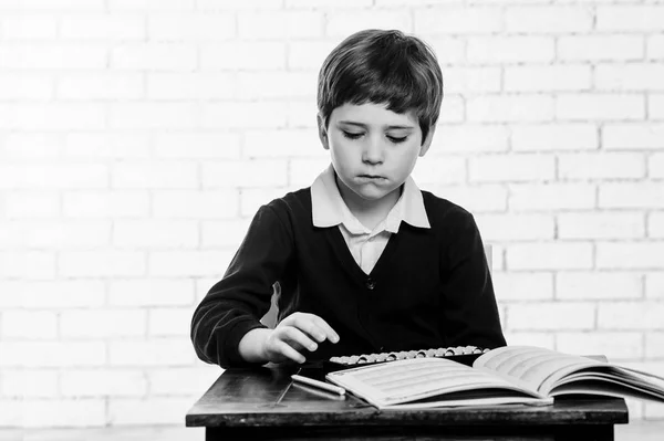 Portrait of primary school boy using abacus mental arithmetic. — Stock Photo, Image