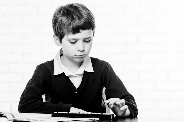 Portrait of primary school boy using abacus mental arithmetic. — Stock Photo, Image