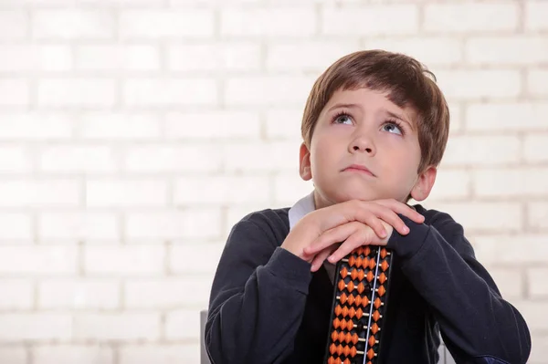 Porträtt av grundskola pojke med abacus huvudräkning. — Stockfoto