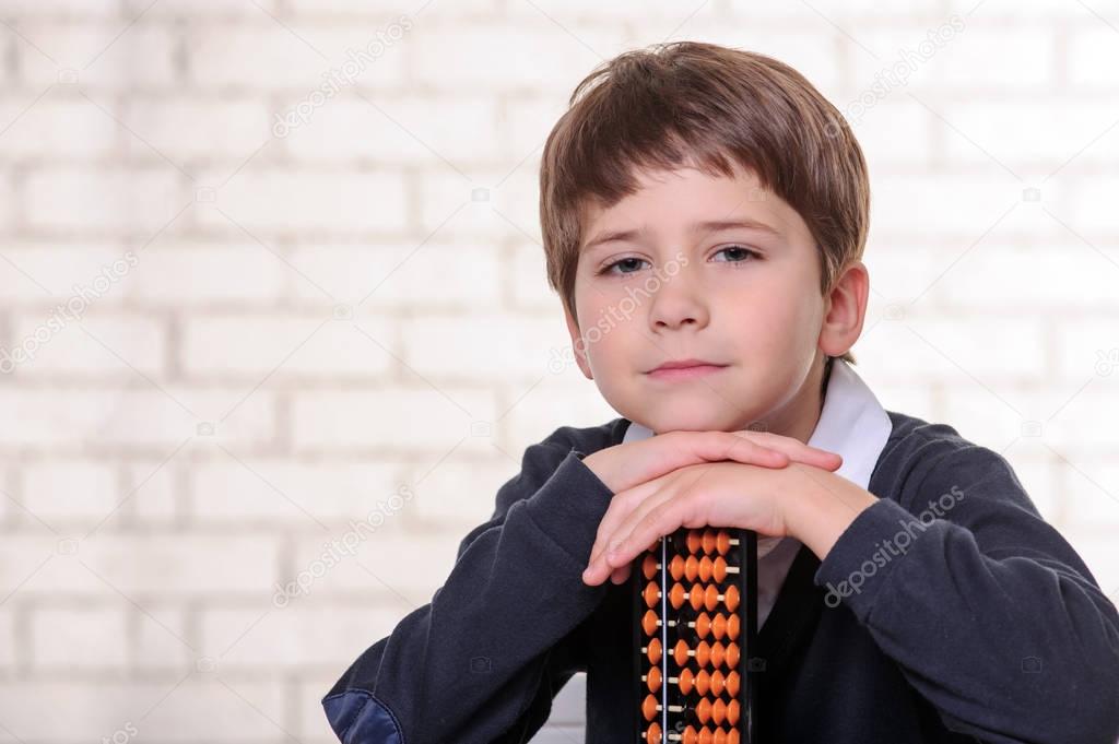 Portrait of primary school boy using abacus mental arithmetic.