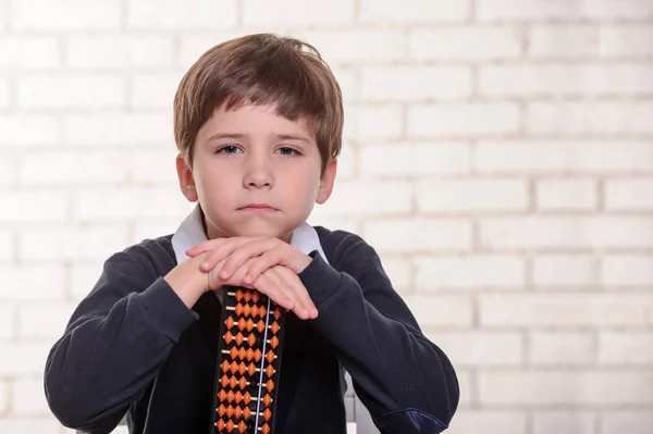 Porträtt av grundskola pojke med abacus huvudräkning. — Stockfoto