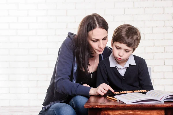 Portrait of primary school boy using abacus mental arithmetic. — Stock Photo, Image