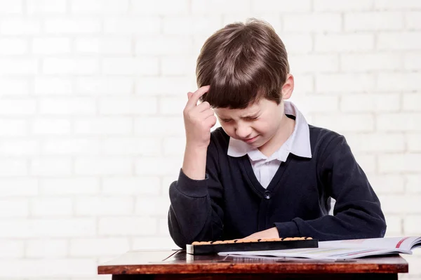 Portrait of primary school boy using abacus mental arithmetic. — Stock Photo, Image