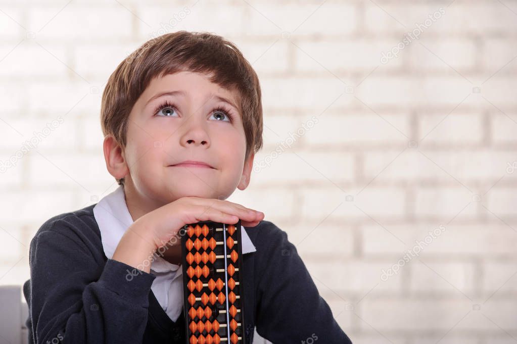 Portrait of primary school boy using abacus mental arithmetic.