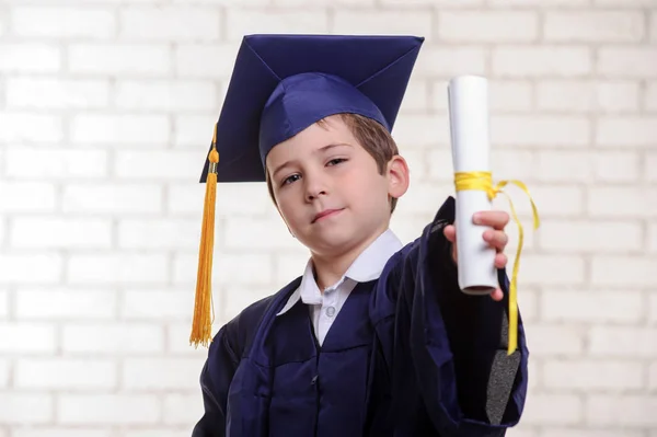 Niño de escuela primaria en copa y vestido posando con diploma . —  Fotos de Stock