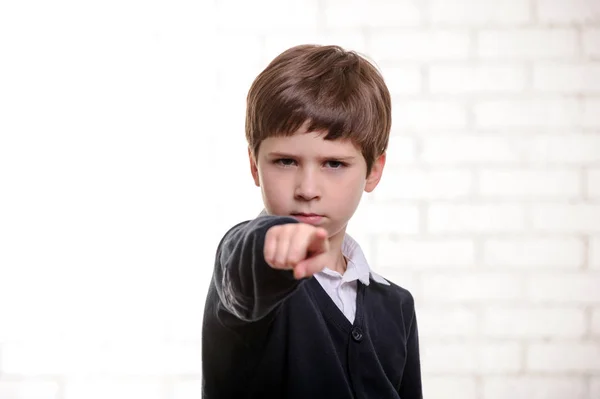 Glad grundskola pojke pekar du med fingret. — Stockfoto