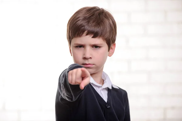 Glad grundskola pojke pekar du med fingret. — Stockfoto