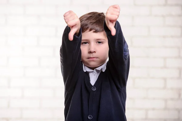 Imagem do menino da escola primária com polegares para baixo . — Fotografia de Stock