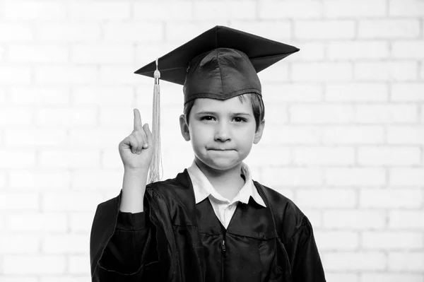 Niño de escuela primaria en copa y vestido posando con diploma . —  Fotos de Stock
