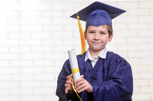 Niño de escuela primaria en copa y vestido posando con diploma —  Fotos de Stock