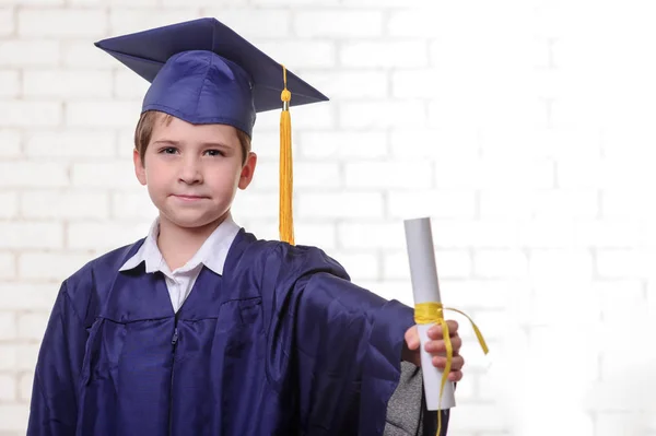 Niño de escuela primaria en copa y vestido posando con diploma —  Fotos de Stock