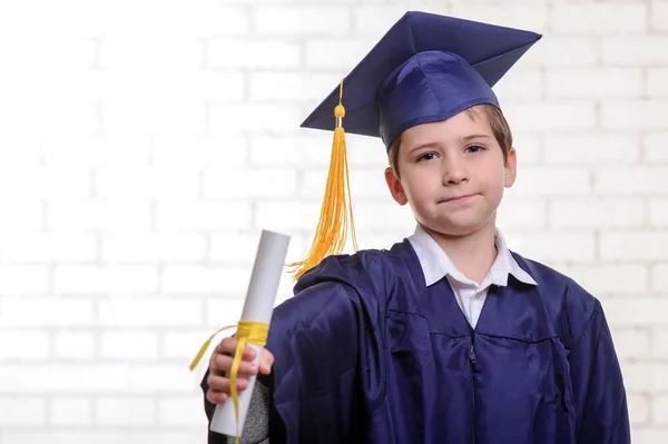 Niño de escuela primaria en copa y vestido posando con su diploma —  Fotos de Stock