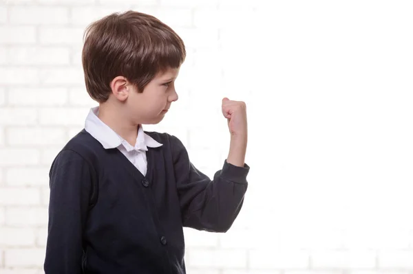 Grundskola pojke gör tecken "Ja" med knytnäven. — Stockfoto