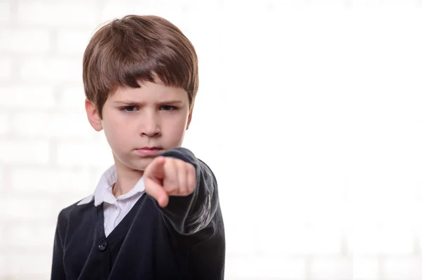 Happy primary school boy points to you with his finger — Stock Photo, Image