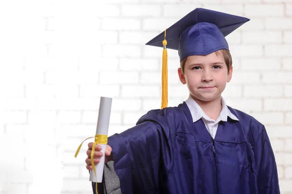 Scuola primaria ragazzo in tazza e abito posa con il dito — Foto Stock