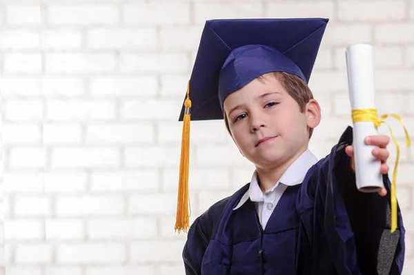 Niño de escuela primaria en copa y vestido posando con su dedo —  Fotos de Stock