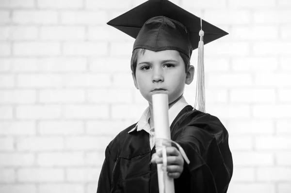 Menino da escola primária em copo e vestido posando com o dedo — Fotografia de Stock