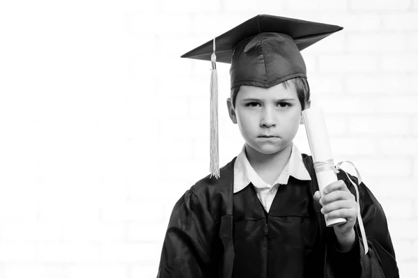 Niño de escuela primaria en copa y vestido posando con su dedo —  Fotos de Stock