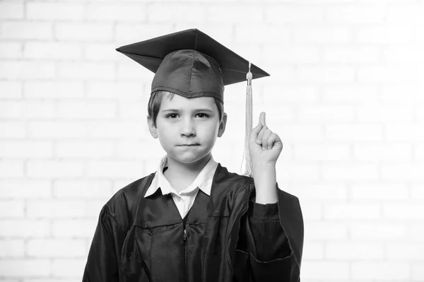 Primária escola menino no copo e vestido posando com o dedo para cima preto e branco — Fotografia de Stock