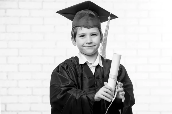 Menino da escola primária em copo e vestido posando com o dedo preto e branco — Fotografia de Stock