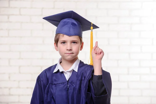 Menino da escola primária em copo e vestido posando com diploma . — Fotografia de Stock