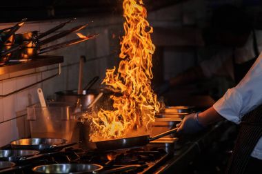 Şef sebze açık yangın wok içinde karıştırma.