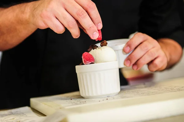 Cheef's hands decorating ise cream with berry. — Stock Photo, Image