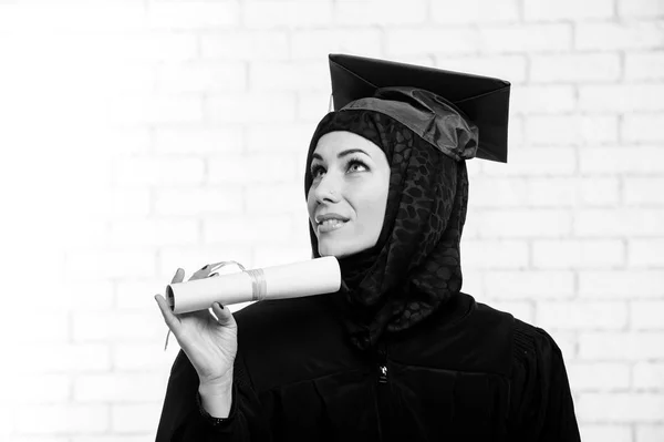 Glücklich Absolvent muslimische Studentin mit Diplom drinnen. Schwarz-Weiß-Bild. — Stockfoto