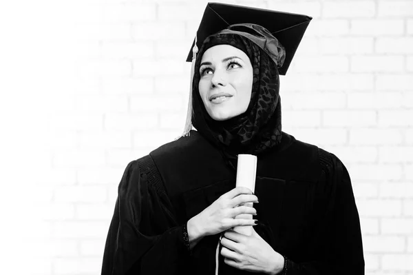 Glücklich Absolvent muslimische Studentin mit Diplom drinnen. Schwarz-Weiß-Bild. — Stockfoto