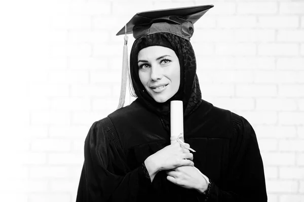 Glücklich Absolvent muslimische Studentin mit Diplom drinnen. Schwarz-Weiß-Bild. — Stockfoto