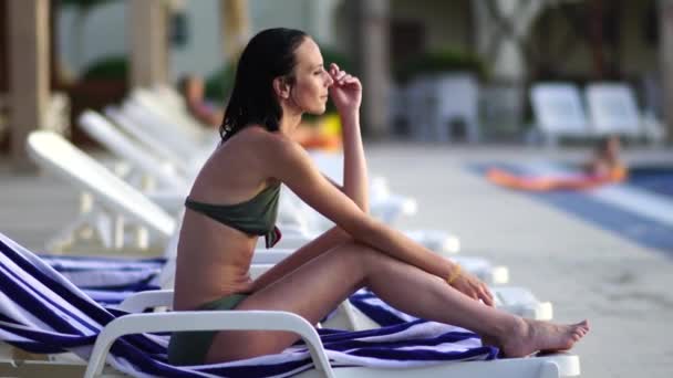Glückliche junge Frau entspannt neben dem Schwimmbad. — Stockvideo