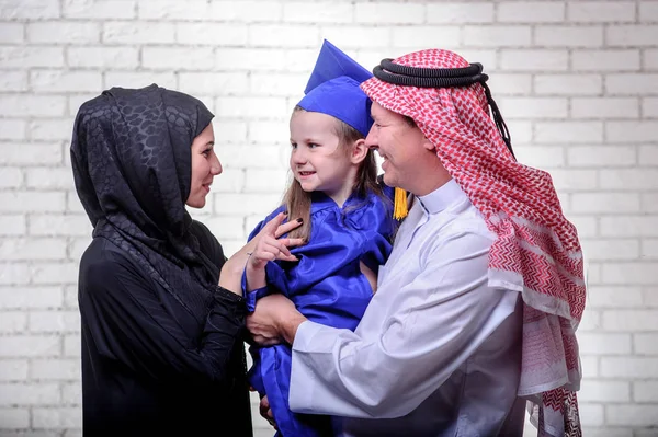 Arabic Middle Eastern family posing with graduating primary school daughter. — Stock Photo, Image