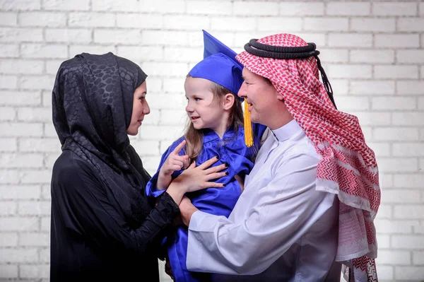 Arabic Middle Eastern family posing with graduating primary school daughter. — Stock Photo, Image