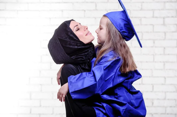 Árabe madre posando con graduación im primaria escolar hija . — Foto de Stock