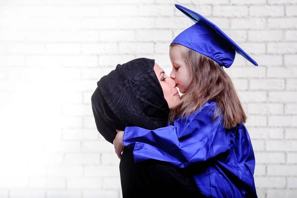 Árabe madre posando con hija graduada . —  Fotos de Stock