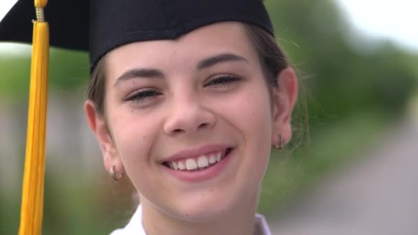 Escena al aire libre de una hermosa estudiante graduada vestida con copa y vestido . — Vídeo de stock