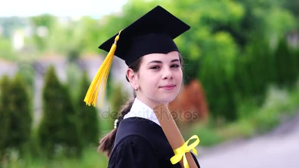 Draußen Szene der schönen Studentin mit Abschluss in Tasse und Kleid. — Stockvideo