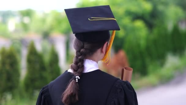 Εξωτερική σκηνή της όμορφης φοιτήτριας αποφοίτηση ντυμένος στο κύπελλο και φόρεμα. — Αρχείο Βίντεο