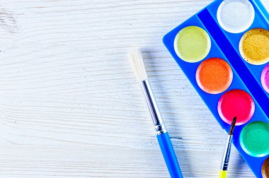  Boya ve ahşap ressam beyaz masa üzerinde fırçaları ile.