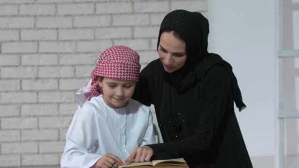 Arabic mother and son reading indoor. — Stock Video