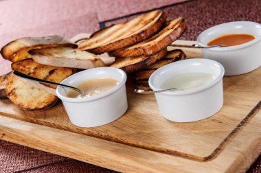 Tost dilim peynirli tava içinde kavrulmuş ve susam kaydı bir sos,