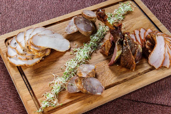 Pierna de ganso al horno en salsa de bayas en un plato de madera  . —  Fotos de Stock